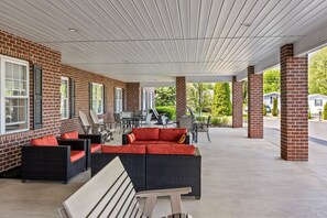 A covered patio area with brick walls, outdoor furniture, and a view of the surrounding neighborhood. - Comfort Suites Hotel and Conference Center (Berlin)
