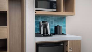 Una cocina equipada con microondas, cafetera y lavavajillas.