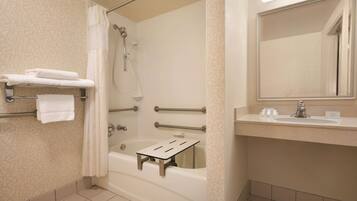 Un baño con bañera, ducha y tocador con espejo.