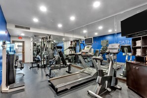 A modern gym with various exercise equipment, including treadmills and weight machines.