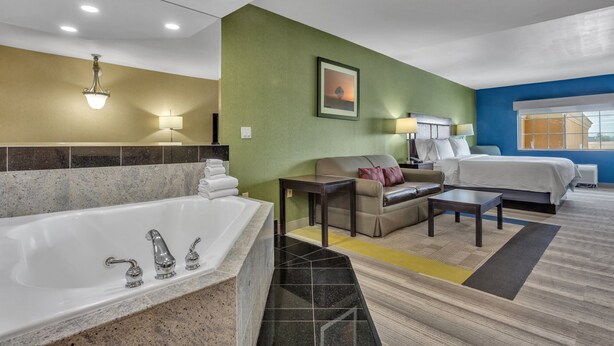A hotel room with a large bathtub, a sofa, a bed, and a small table. - Holiday Inn Express Hotel & Suites El Centro by IHG (El Centro)