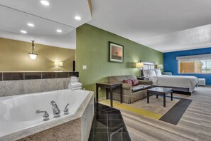 A hotel room with a large bathtub, a sofa, a bed, and a small table. - Holiday Inn Express Hotel & Suites El Centro by IHG (El Centro)