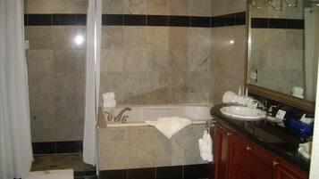A bathroom with a shower, bathtub, and a large mirror.