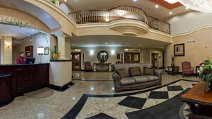 A hotel lobby with a reception desk, a sofa, and a balcony. - Holiday Inn Express Hotel & Suites El Centro by IHG (El Centro)