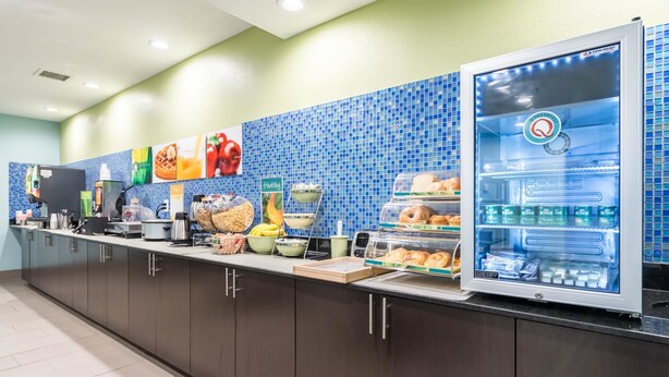 Una barra de desayuno con un refrigerador que exhibe diversos alimentos y una balanza digital.
