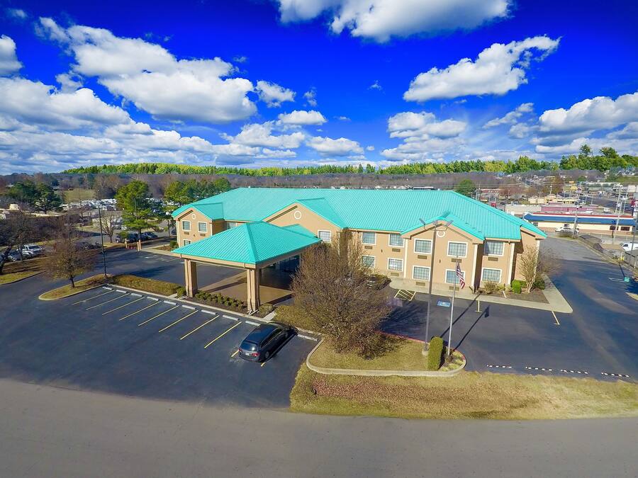 A hotel with a parking lot and a covered area.
