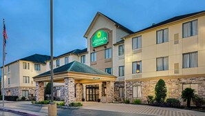 A hotel with a prominent sign, a covered entrance, and a flag.