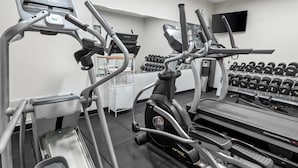 Una palestra con tapis roulant, ellittiche e un espositore per manubri.