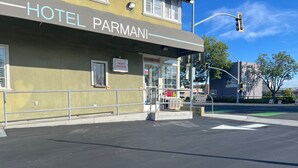 A building with a sign reading 'HOTEL PARMANI' and a 'NIGHT WINDOW' sign. - Hotel Parmani (Palo Alto)