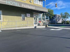 Un edificio con un letrero que dice 'HOTEL PARMANI' y un letrero que indica 'NIGHT WINDOW'.