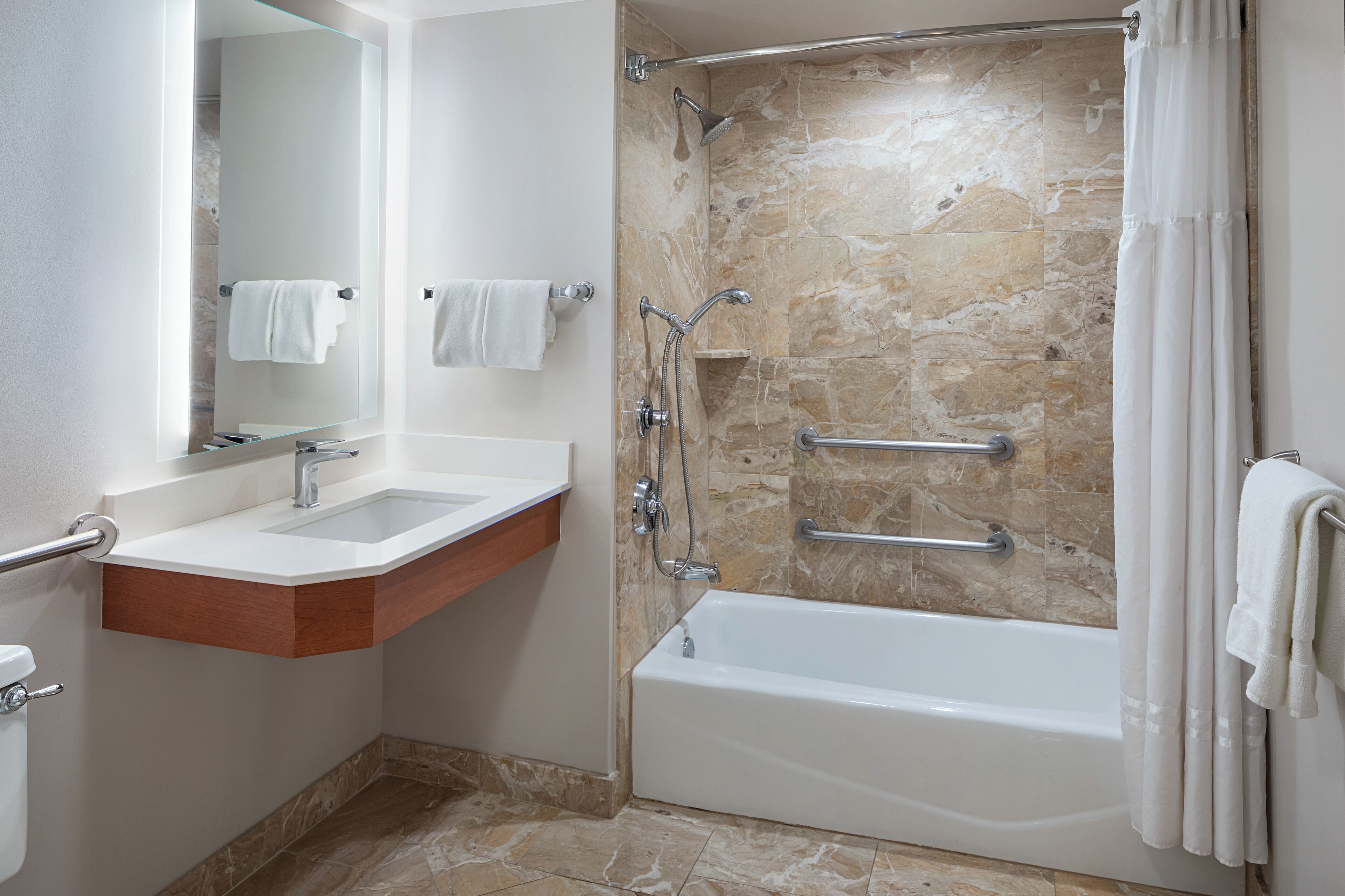 A modern bathroom with a glass-enclosed shower, a white sink, and a bathtub.