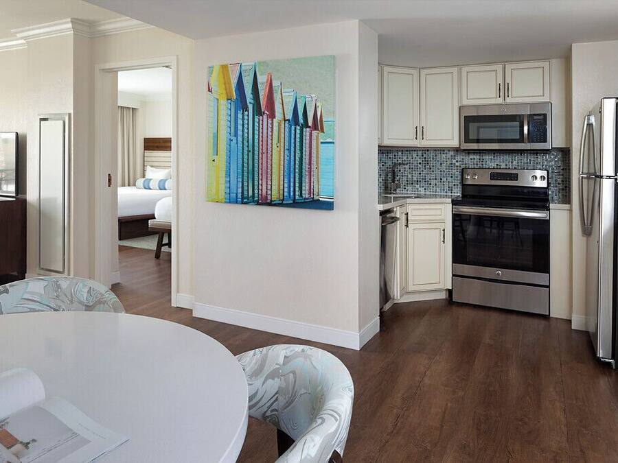 A modern kitchen with white cabinets, stainless steel appliances, and a tiled backsplash.
