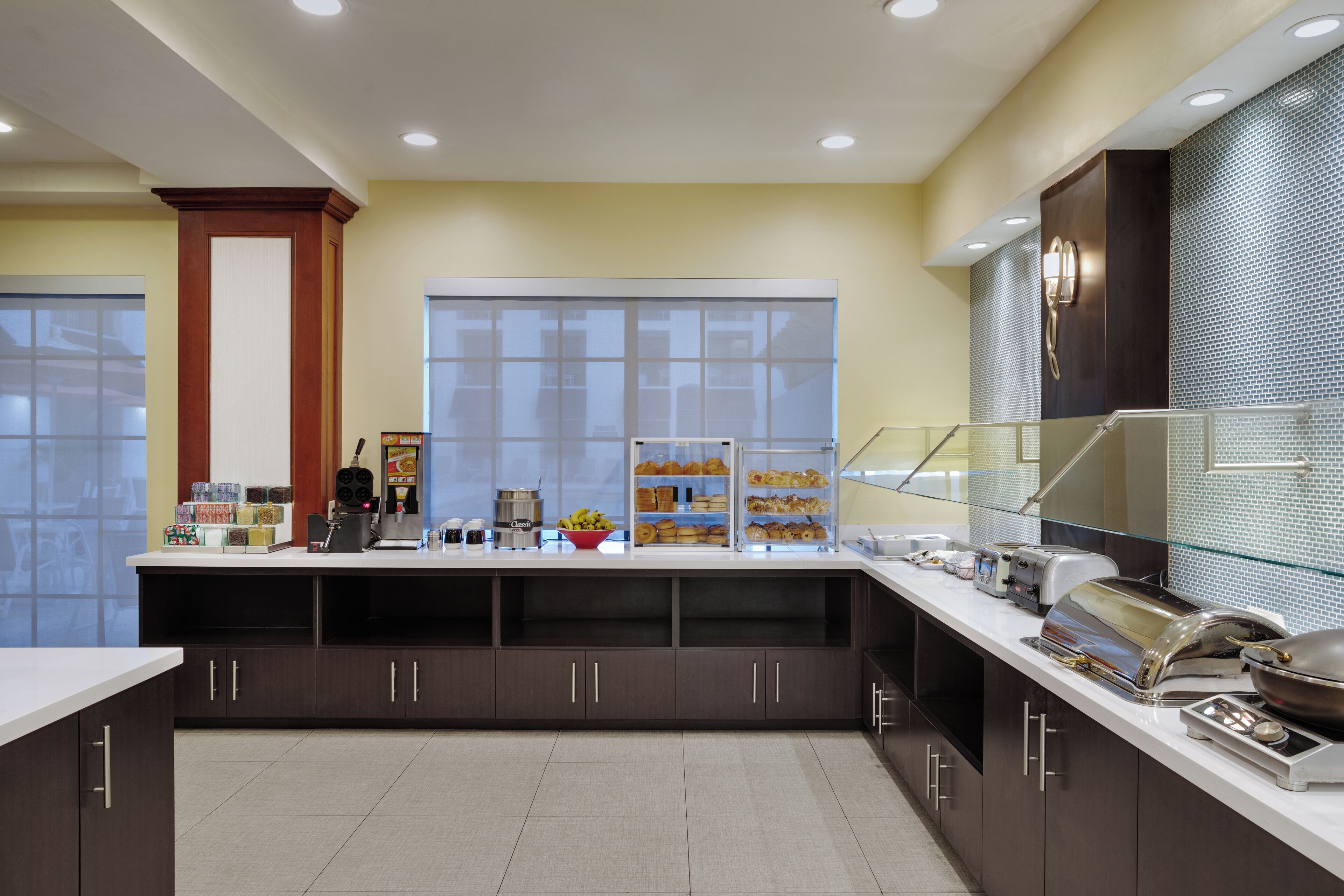 Una cocina moderna con una encimera amplia, electrodomésticos integrados y un ventanal grande.