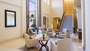 A spacious lobby with a high ceiling, large windows, and a staircase leading to an upper floor. - Hilton Lake Las Vegas Resort and Spa (Henderson)