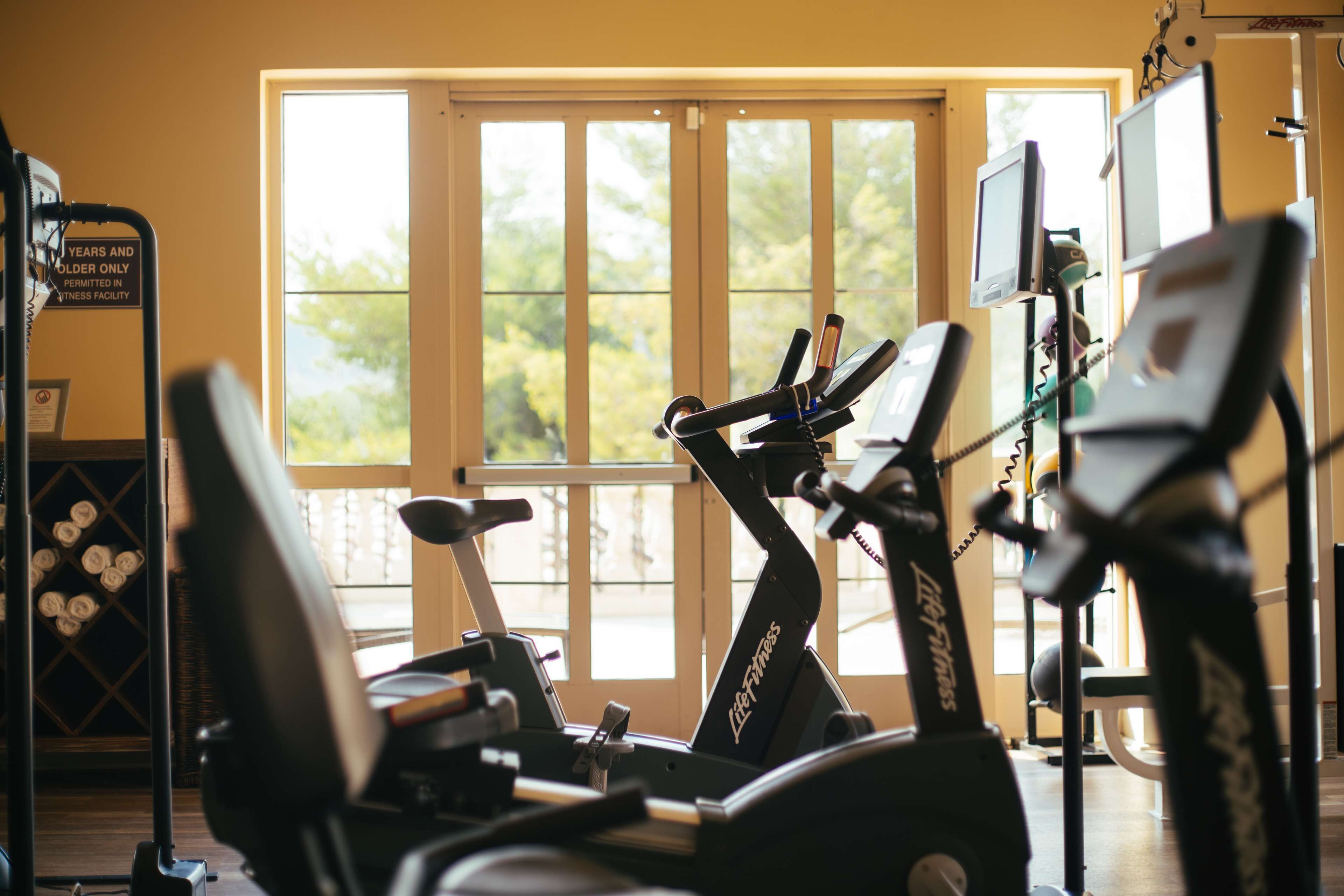 A gym with stationary bikes, a treadmill, and exercise equipment.