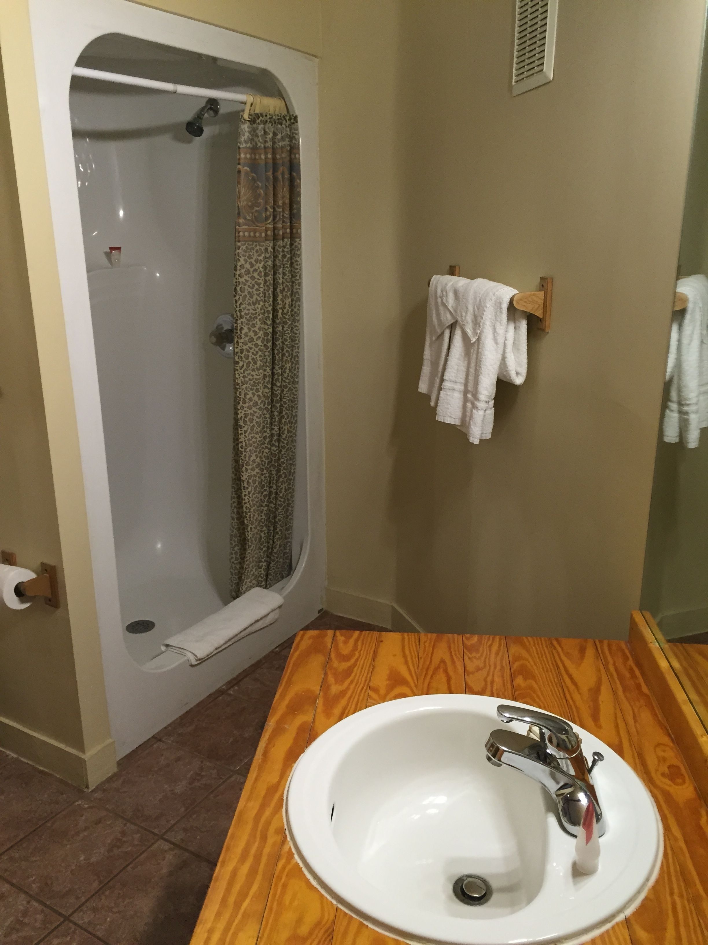 A bathroom with a bathtub, a wooden vanity with a sink, and a towel rack.