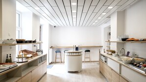 Una cucina moderna con mobili in legno, un'isola centrale, sgabelli da bar e diversi elettrodomestici.