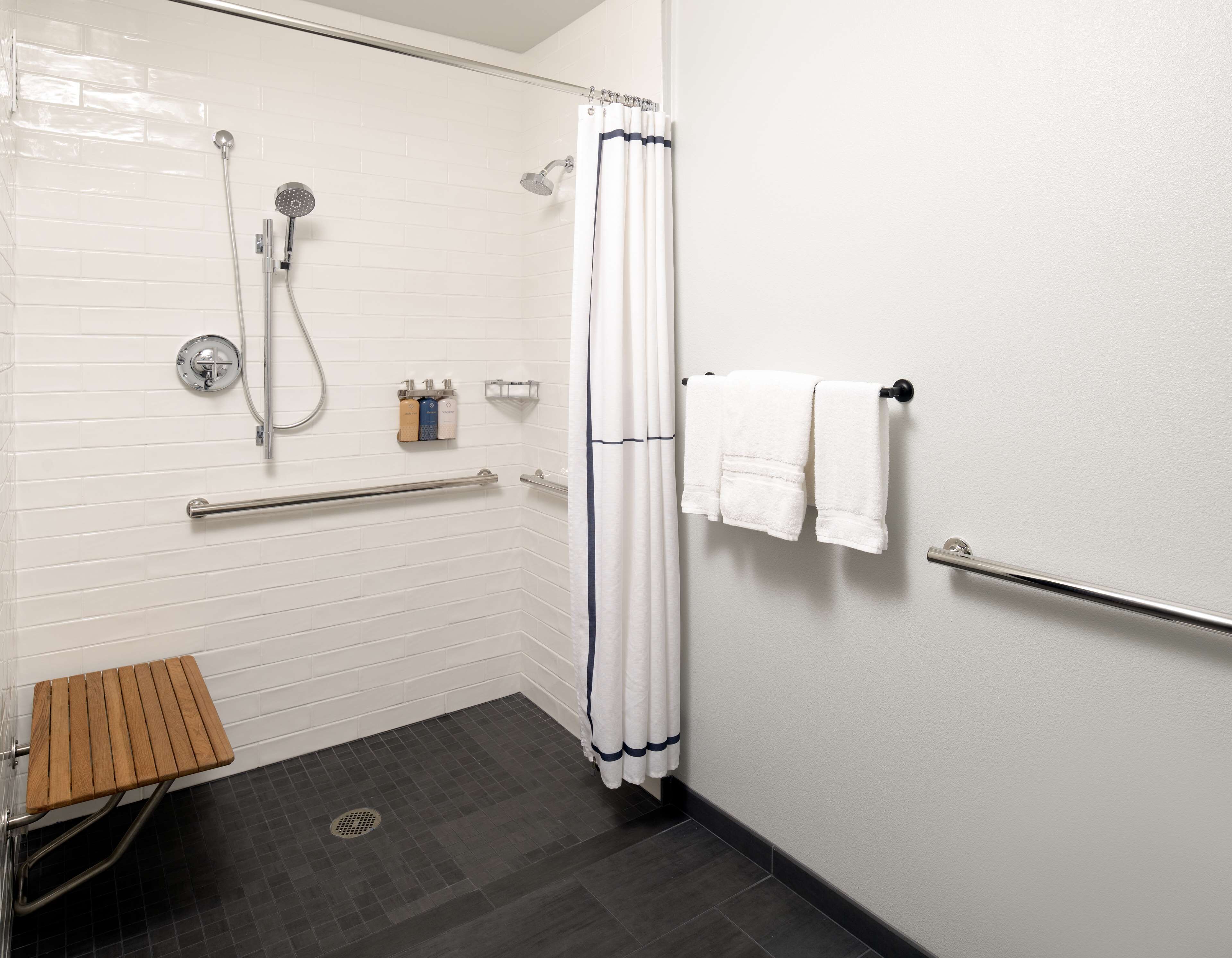 Ein modernes Badezimmer mit Dusche, Toilette, Handtrockner und Handtuchhalter.