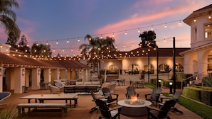 An outdoor patio area with string lights, seating, and a fire pit. - Hayes Mansion, San Jose - Curio Collection by Hilton (San Jose)