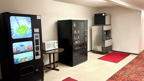 A kitchenette with a microwave, refrigerator, and a beverage vending machine. - Americas Best Value Inn Laramie (Laramie)