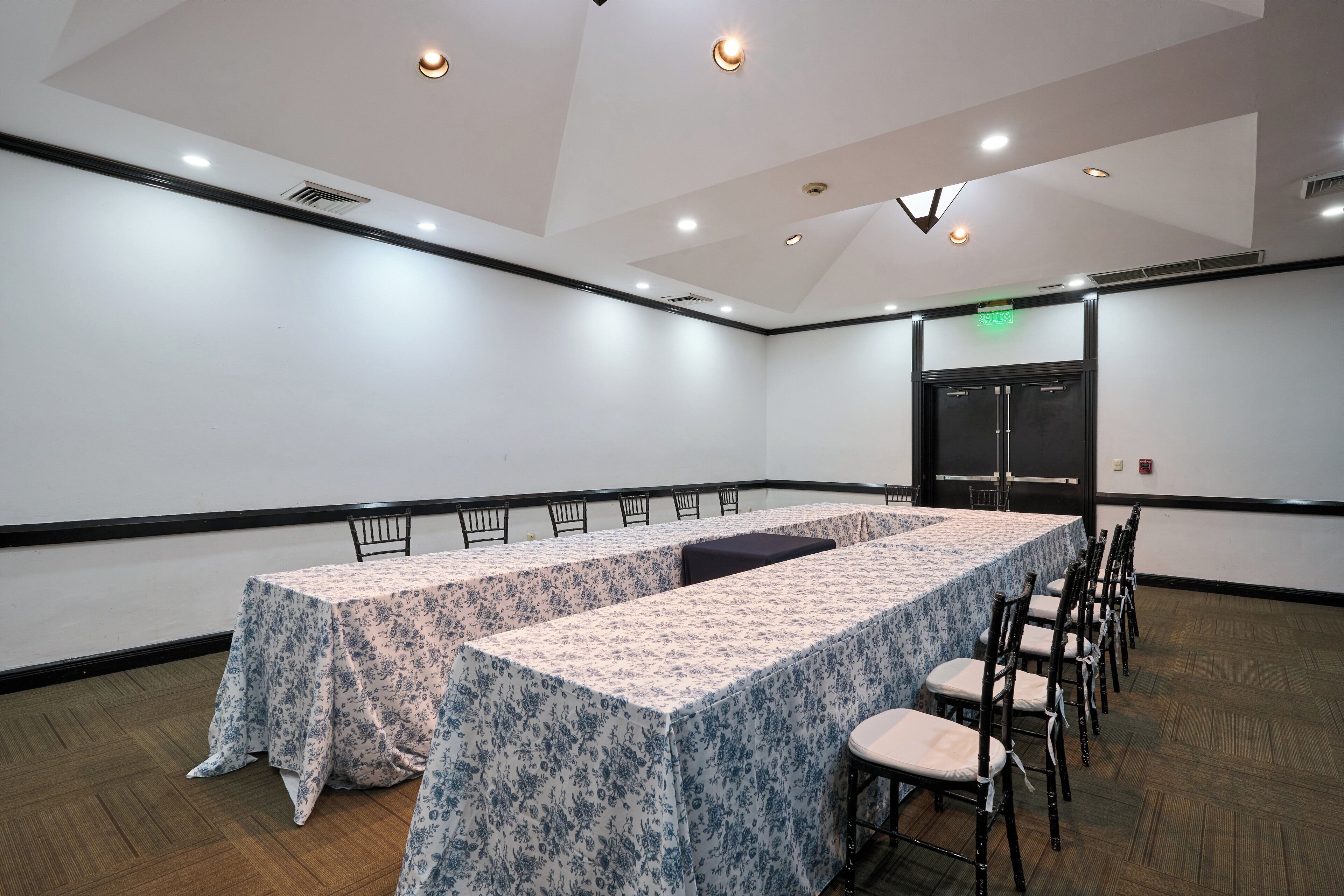 A conference room with a long table, chairs, and a door.