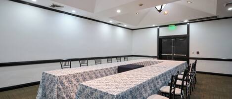 A conference room with a long table, chairs, and a door.