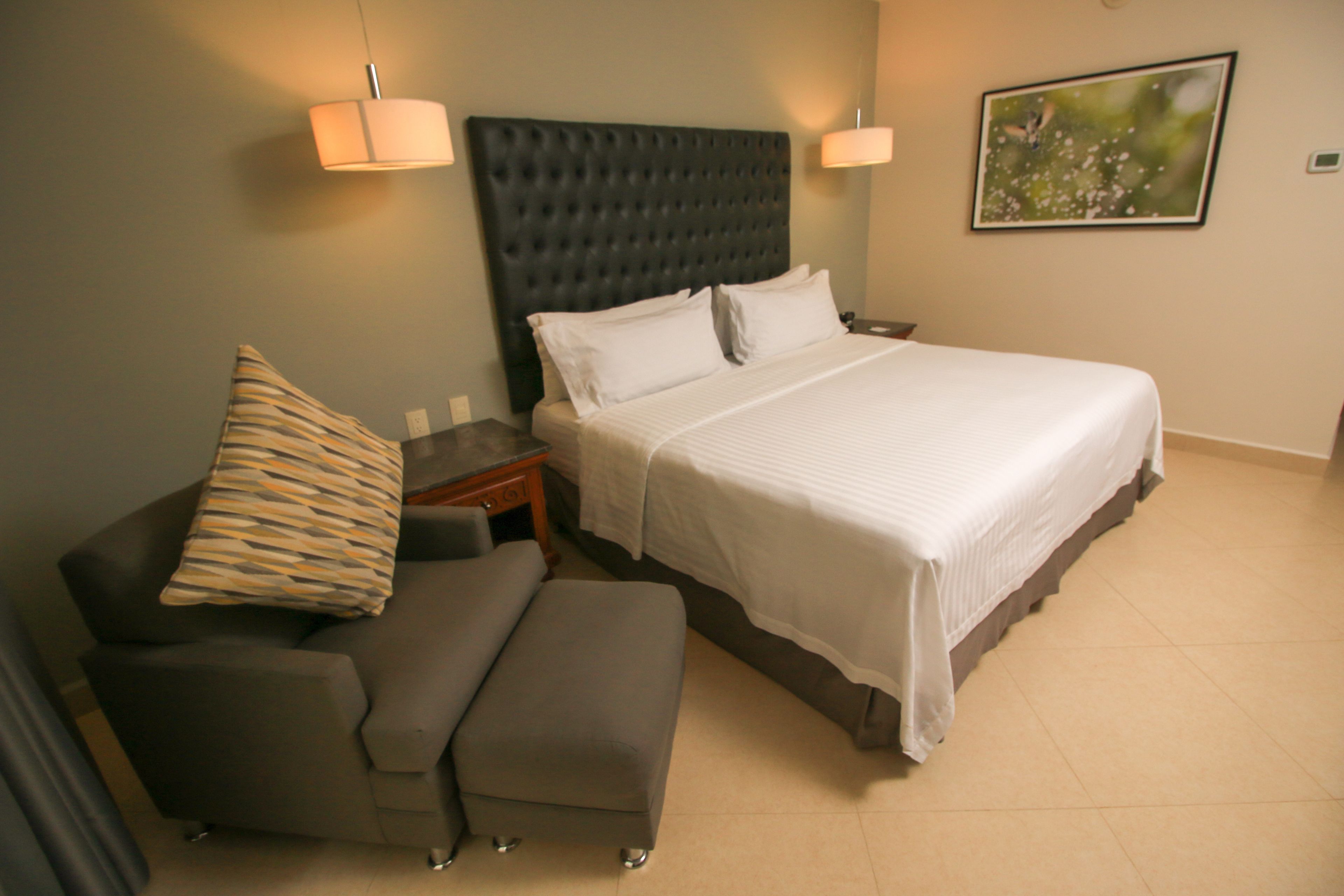 Une chambre d’hôtel moderne avec un grand lit, un canapé et une petite table.