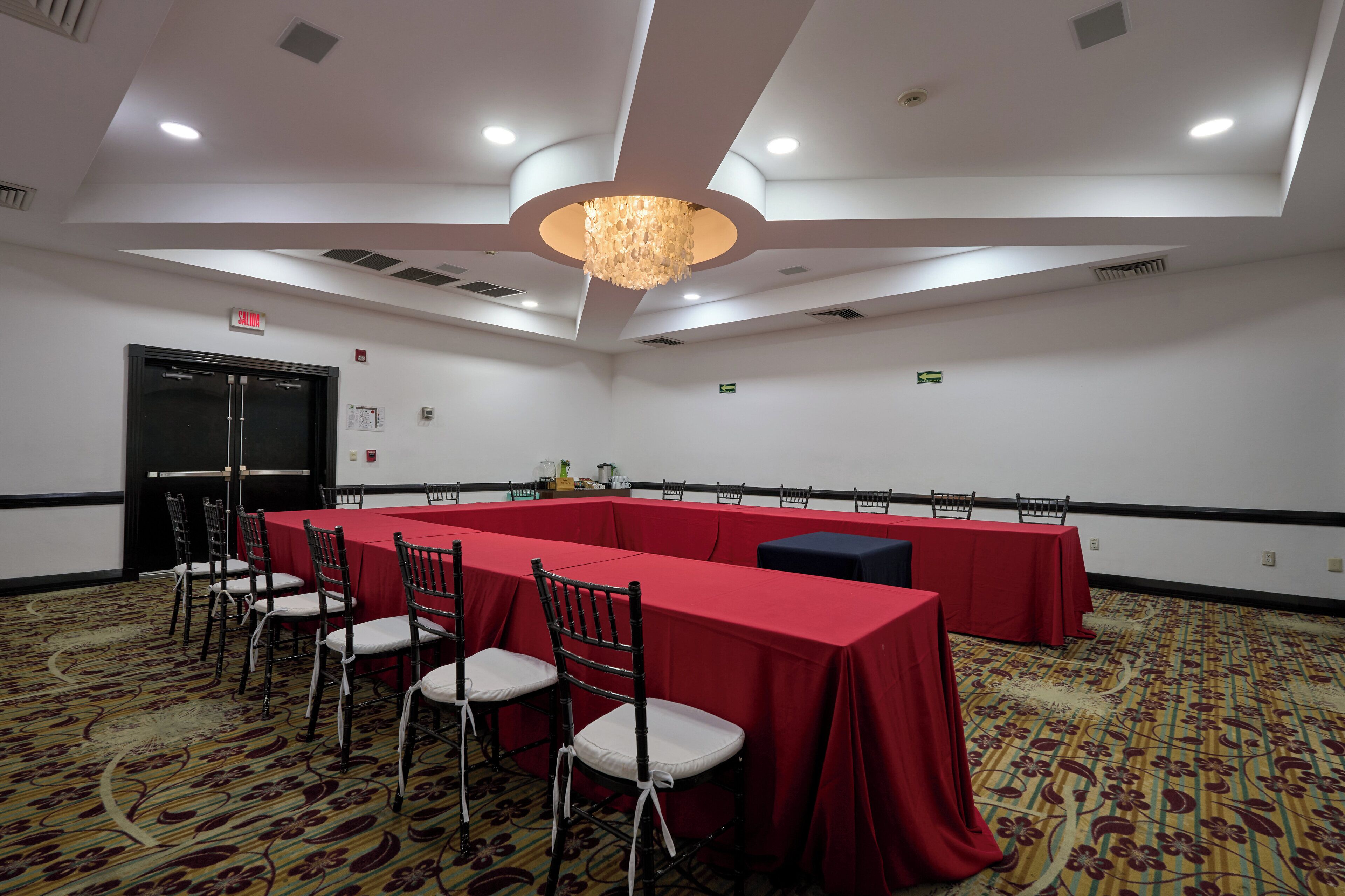 A conference room with a long table, chairs, and a chandelier.