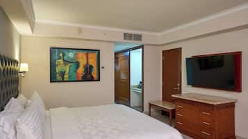 A hotel room with a bed, a painting, a TV, and a wooden cabinet.