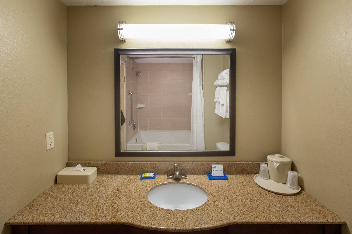 Une salle de bain équipée d’un lavabo, d’un miroir et d’un porte-serviettes.