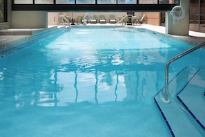 A swimming pool with a diving board and lounge chairs. - Holiday Inn Express & Suites Jacksonville Airport by IHG (Jacksonville)
