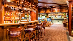 A bar area with wooden decor, bar stools, and a variety of liquor bottles. - Bangkok Palace Hotel (Bangkok)