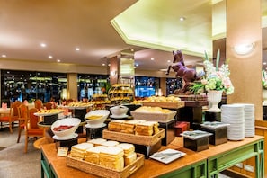 A buffet area with various food items and a decorative horse statue.