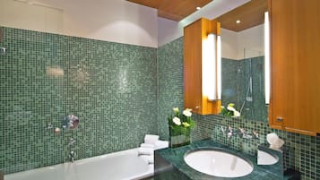 Un baño moderno con una bañera grande, dos lavamanos y un espejo sobre el lavabo.
