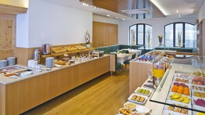 Un buffet de petit-déjeuner moderne offrant un large choix d'aliments, notamment des fruits, des viennoiseries et des boissons.