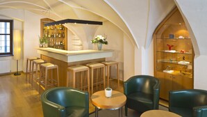 Un espace bar avec des tabourets, un comptoir et un présentoir avec des étagères en verre.