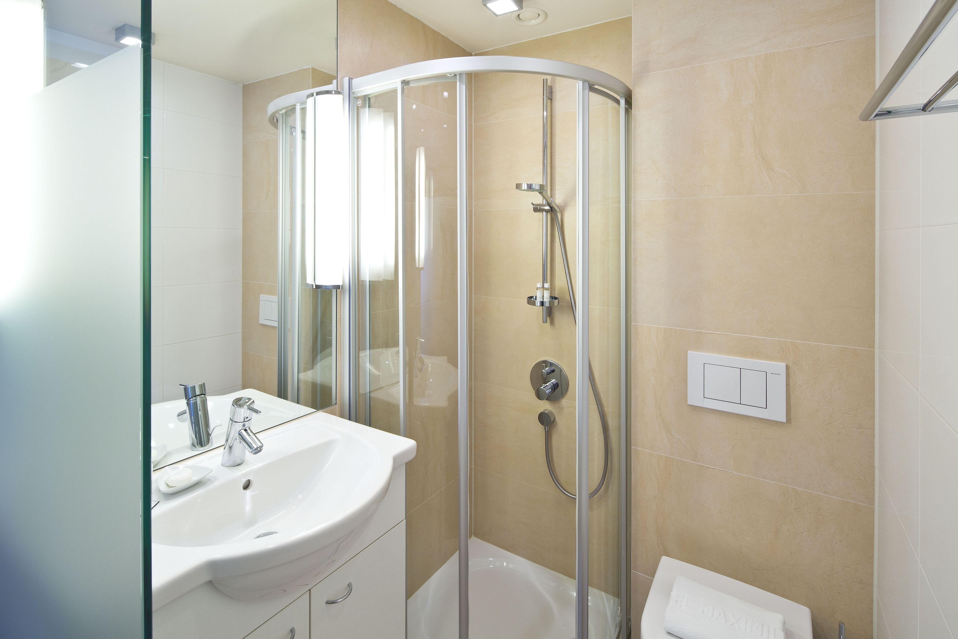 A modern bathroom with a glass-enclosed shower, a white sink, and a bathtub.