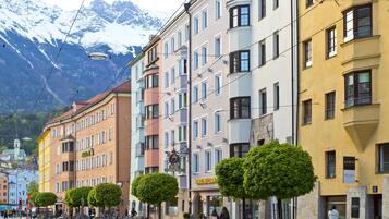 A row of colorful buildings with a hotel named "Maximilian" and a sign for "MEN" on the right.