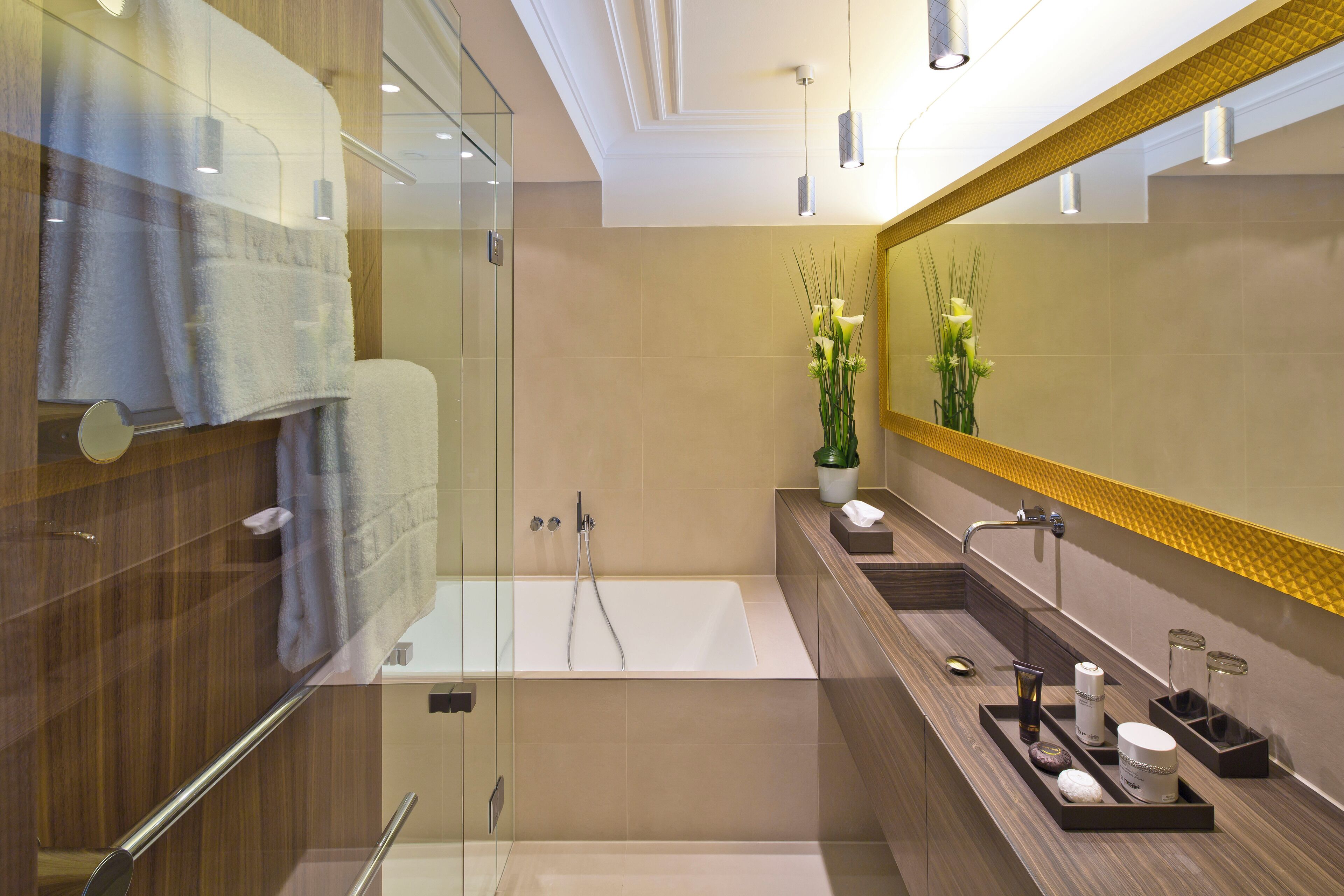 Un baño moderno con cabina de ducha de vidrio, bañera y tocador con espejo.