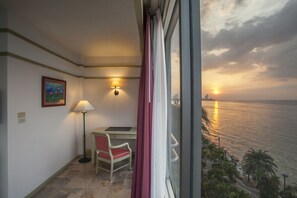 A room with a desk, chair, lamp, and a painting on the wall. - Cholchan Pattaya Beach Resort (Pattaya)