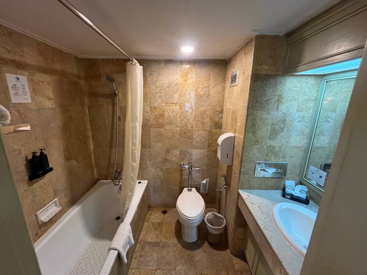 Un baño pequeño con bañera, inodoro y ducha.