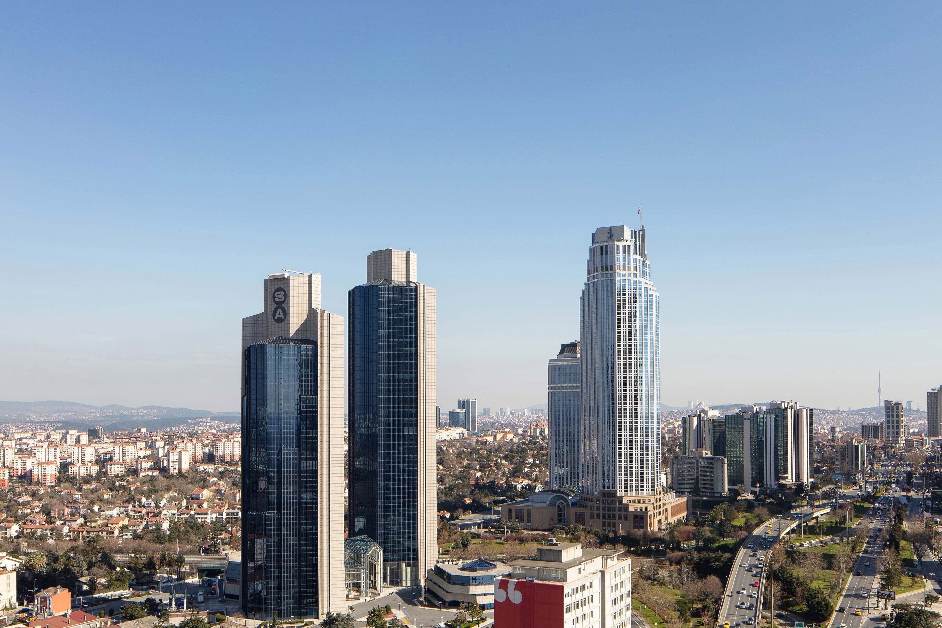 Un paisaje urbano con edificios modernos, cielo despejado y zonas residenciales y comerciales.