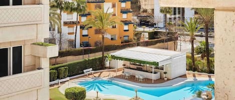 Una piscina al aire libre, sillones reclinables de piscina