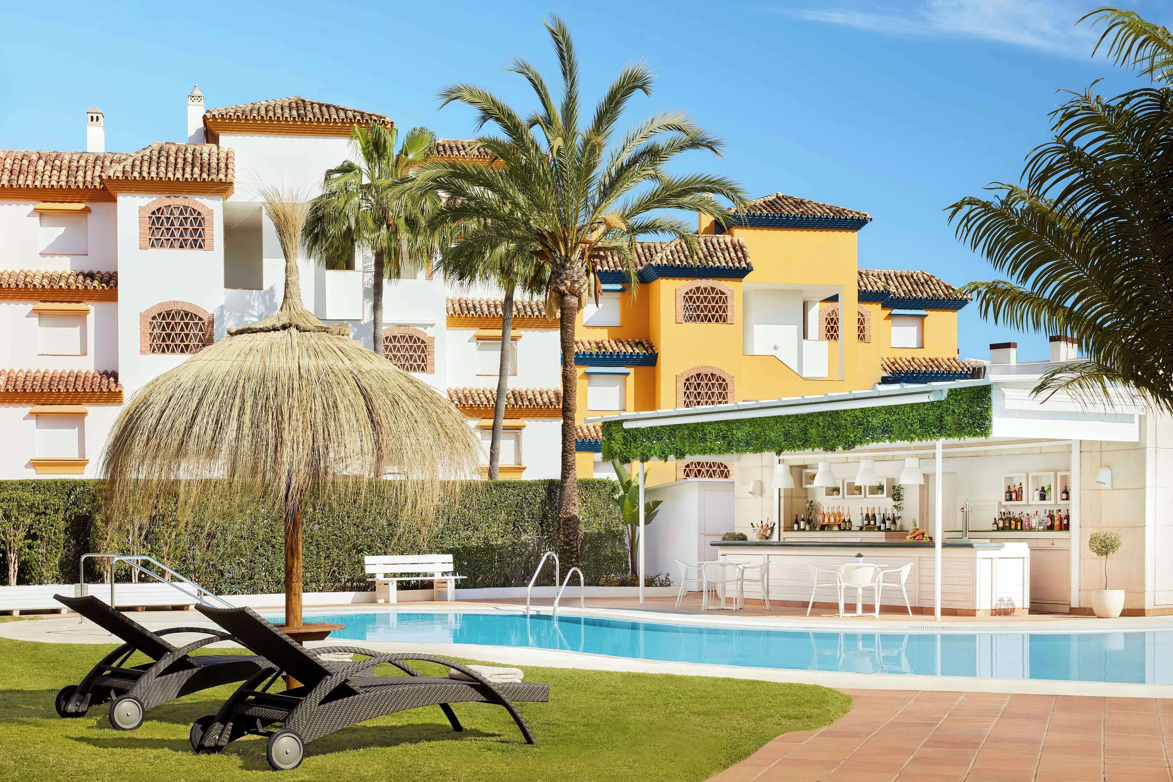 Una piscina al aire libre, sillones reclinables de piscina