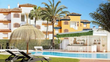 Una piscina al aire libre, sillones reclinables de piscina