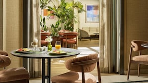 Un comedor con una mesa lista para dos personas, un sofá y una silla.