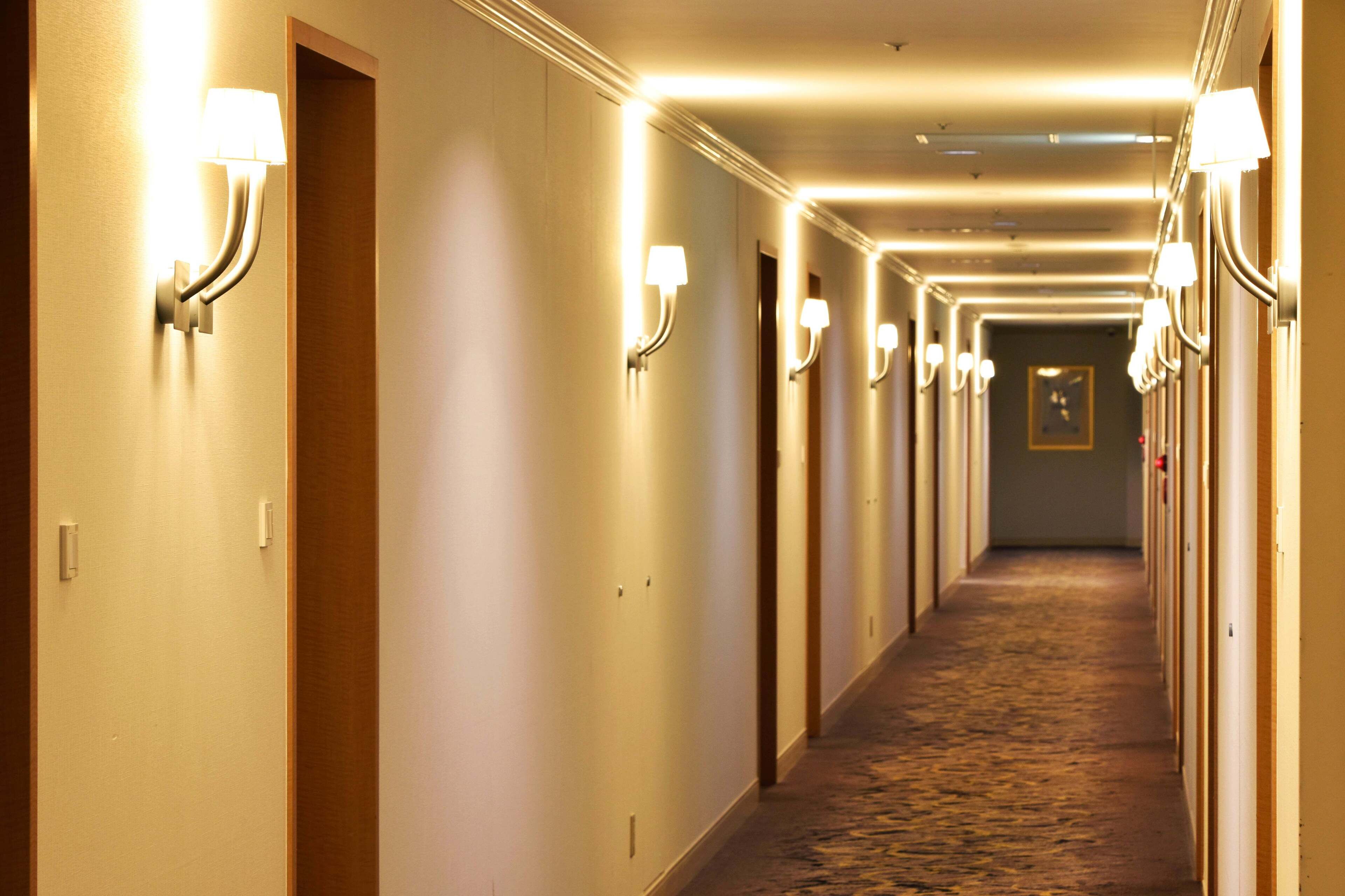 A hotel hallway with multiple doors, each with a light fixture above.