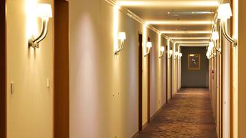 A hotel hallway with multiple doors, each with a light fixture above.