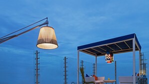 A rooftop terrace with a white sofa set, patterned chairs, a round table, and a hanging light fixture. - The Park Chennai (Chennai)