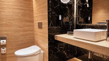 Une salle de bain moderne comprenant des toilettes, un meuble-lavabo avec un évier et un miroir.